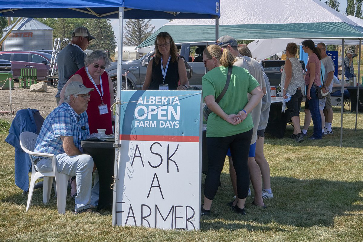 Claudette Lacombe assists John Kolk and Catherine Kerkhoff in the Ask A Farmer booth at Farming Smarter's Open Farm Days event in 2024